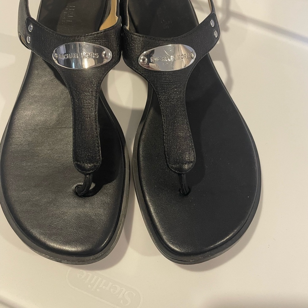 MICHAEL Michael Kors Black Thong Sandal with Silver Logo Plaque
